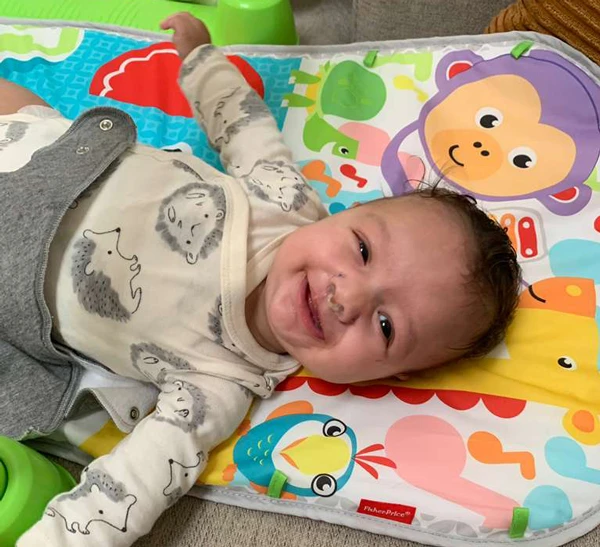 smiling baby samuel in his onesie.