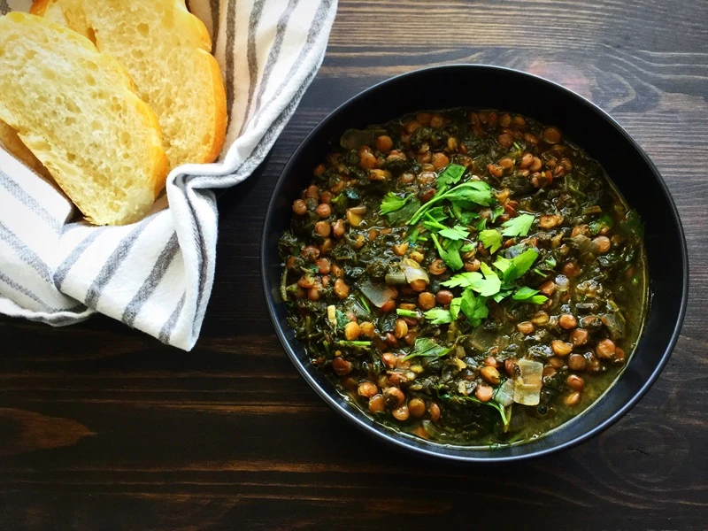 Lentil and spinach soup with a side of bread.