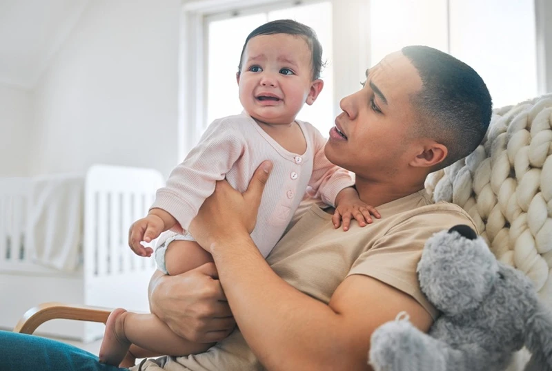 dad soothing crying baby.