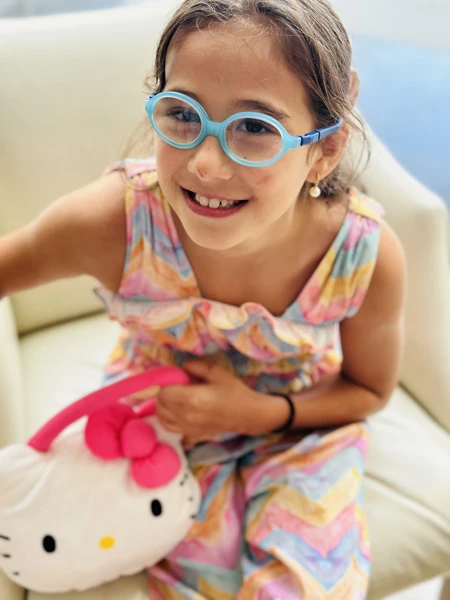 retrato de victoria sonriente con vestido colorido y gafas azules.
