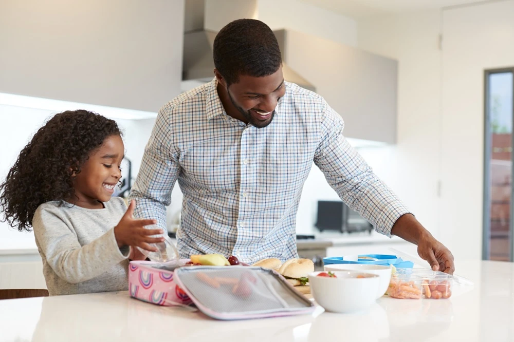 Dad making daughter's lunch.