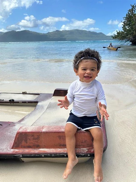 Fernando happily sitting on a sandy beach.