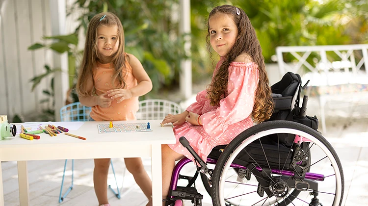 two girls, one in wheelchair.