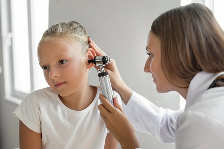 Doctor examining girl's ear.