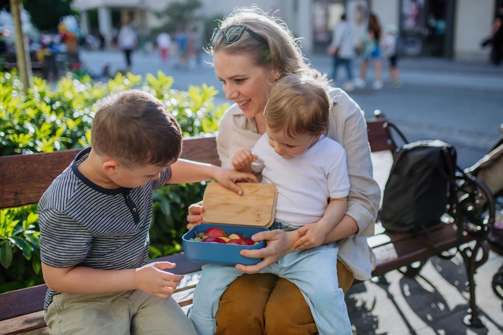 Mom giving kids snacks on the go.
