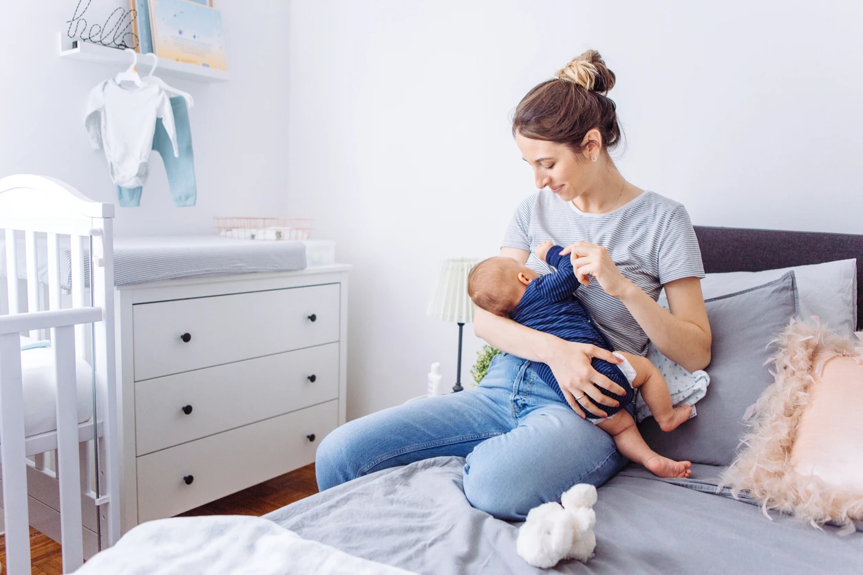 Mom breastfeeding baby in nursery.