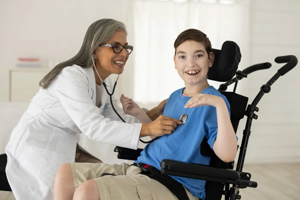 female doctor checking heart beat of boy with muscular dystrophy in wheelchair.